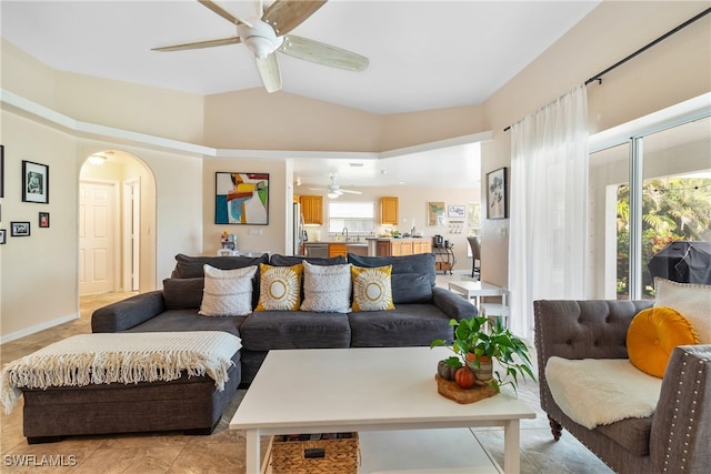 living room featuring light tile patterned floors, ceiling fan, lofted ceiling, and sink