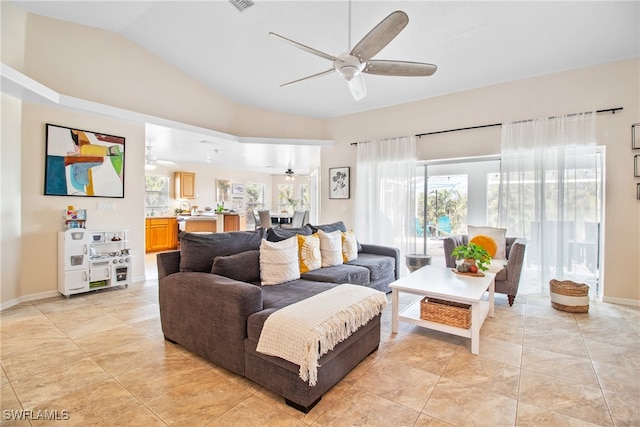 living room featuring ceiling fan, light tile patterned flooring, lofted ceiling, and a wealth of natural light