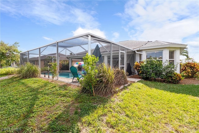 rear view of property with a yard and a lanai