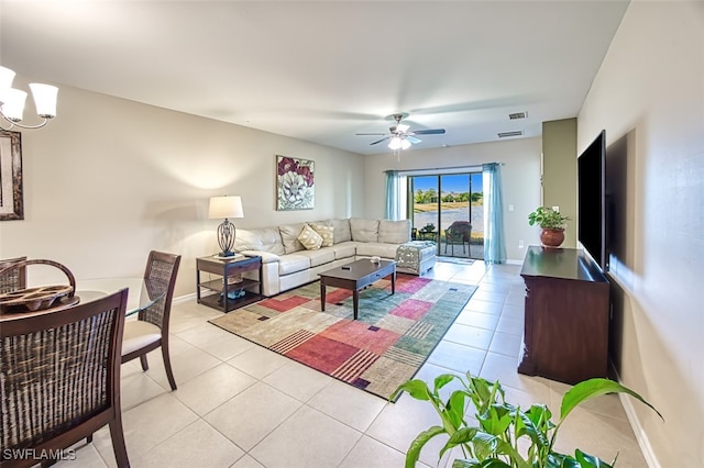 living room featuring ceiling fan with notable chandelier and light tile patterned floors