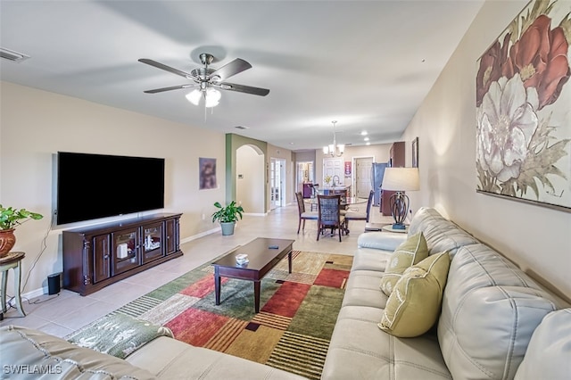 living room featuring light tile patterned flooring and ceiling fan with notable chandelier