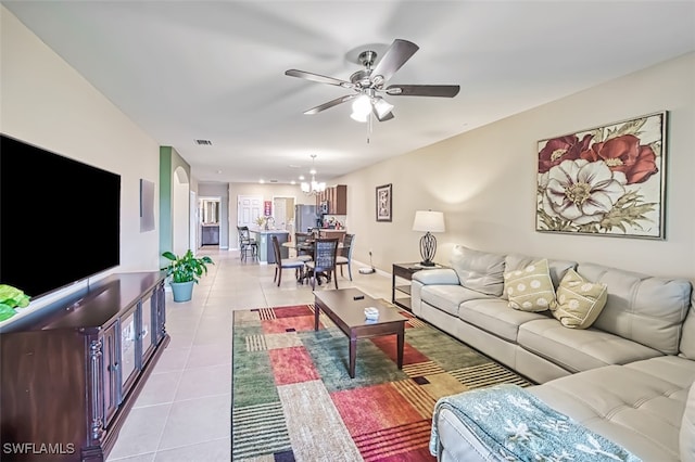 living room featuring light tile patterned flooring and ceiling fan with notable chandelier