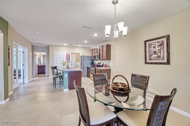 dining room featuring a notable chandelier, sink, and light tile patterned floors