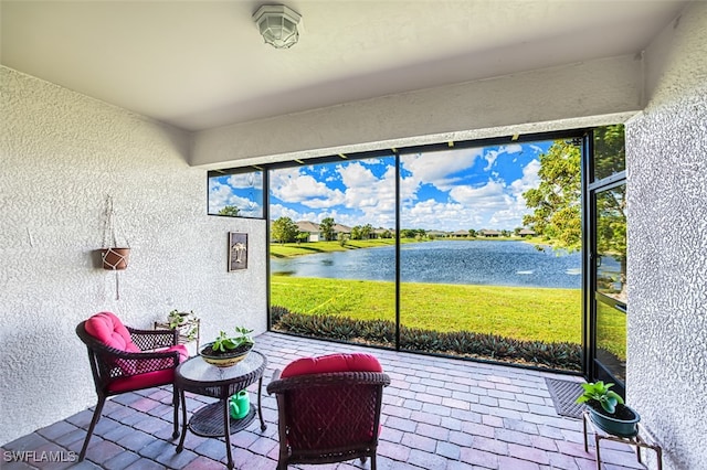 sunroom / solarium featuring plenty of natural light and a water view