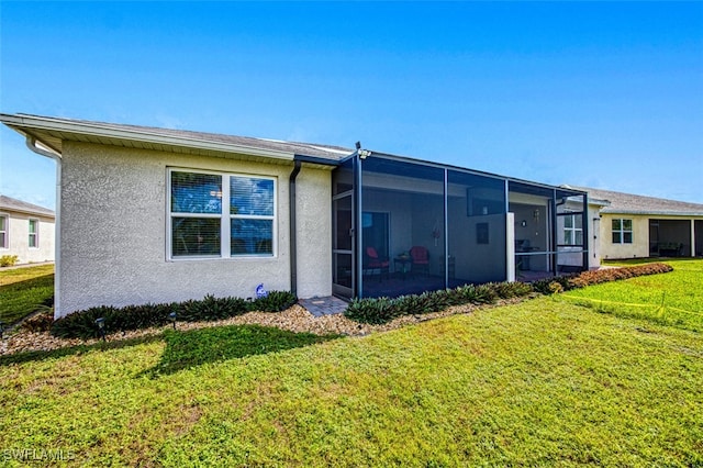 rear view of house with a sunroom and a yard