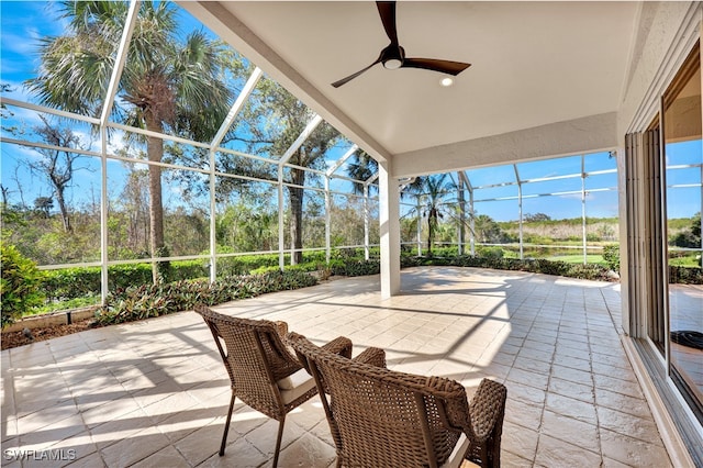 view of patio / terrace with ceiling fan and a lanai