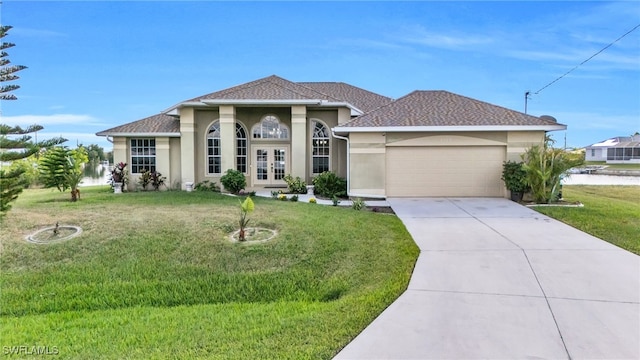 view of front of property featuring a garage, a front lawn, and french doors