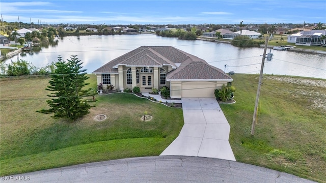 view of front facade with a water view, a garage, and a front lawn