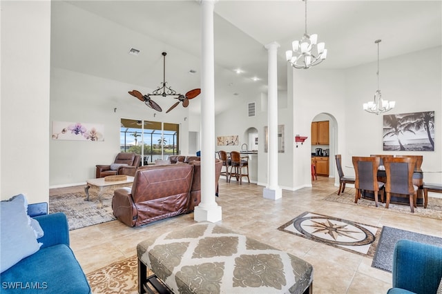 living room with high vaulted ceiling, a chandelier, and ornate columns