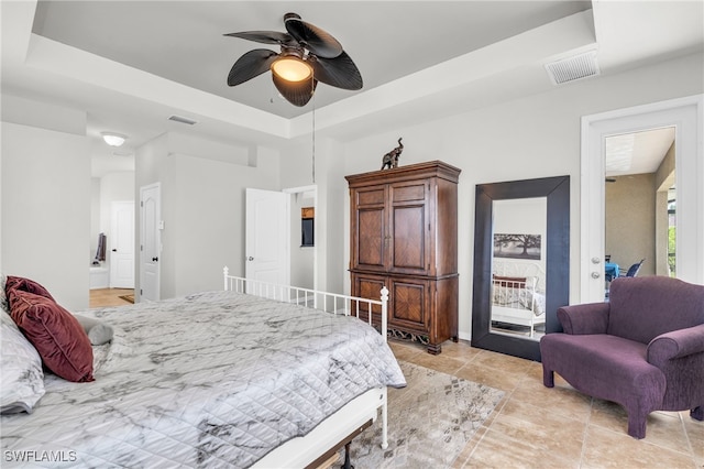 tiled bedroom with a raised ceiling and ceiling fan