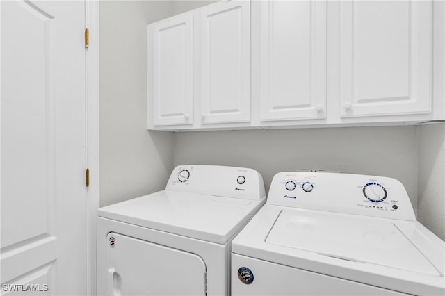 laundry room featuring cabinets and washing machine and clothes dryer