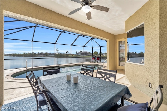 view of patio featuring a water view, ceiling fan, and a lanai