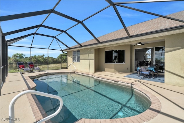 view of pool with ceiling fan, a lanai, and a patio area