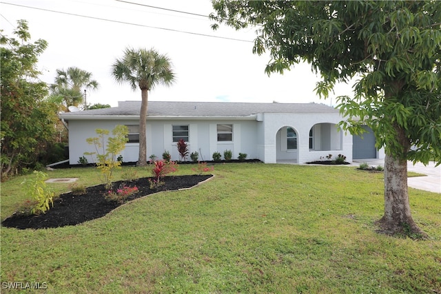 ranch-style house featuring a garage and a front lawn