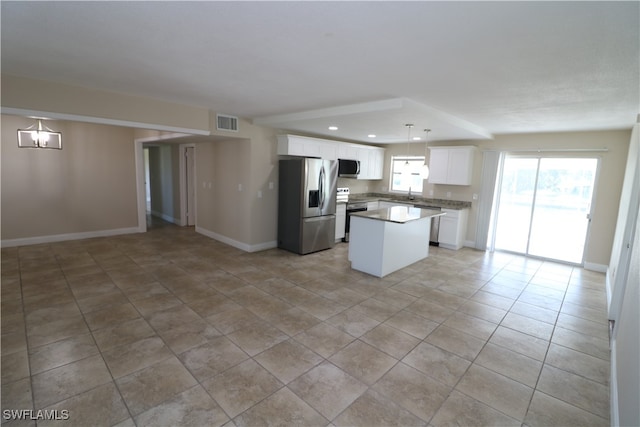 kitchen with stainless steel appliances, white cabinets, sink, a kitchen island, and decorative light fixtures