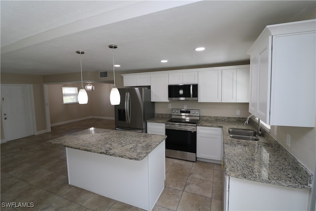 kitchen featuring stainless steel appliances, a kitchen island, pendant lighting, sink, and white cabinets