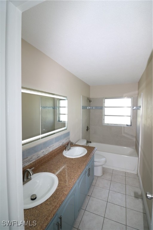 full bathroom featuring toilet, vanity, tiled shower / bath, and tile patterned flooring