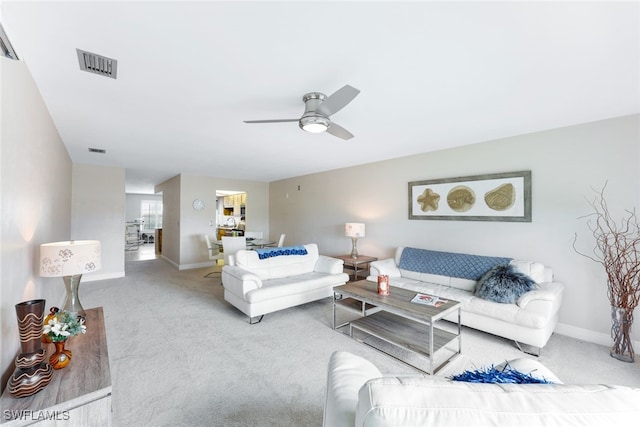 living room with ceiling fan and light colored carpet