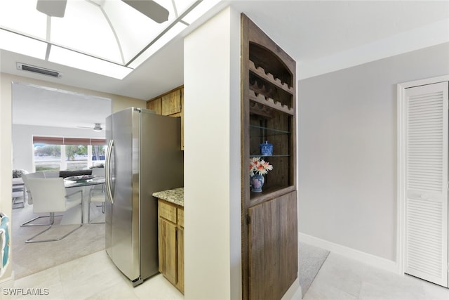 kitchen featuring stainless steel refrigerator and light tile patterned flooring