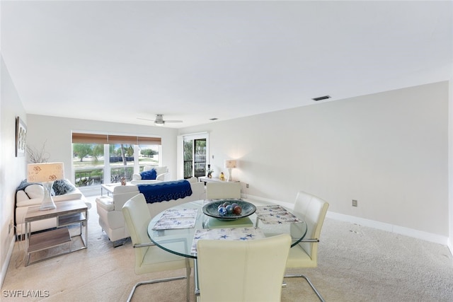 dining space featuring light colored carpet and ceiling fan