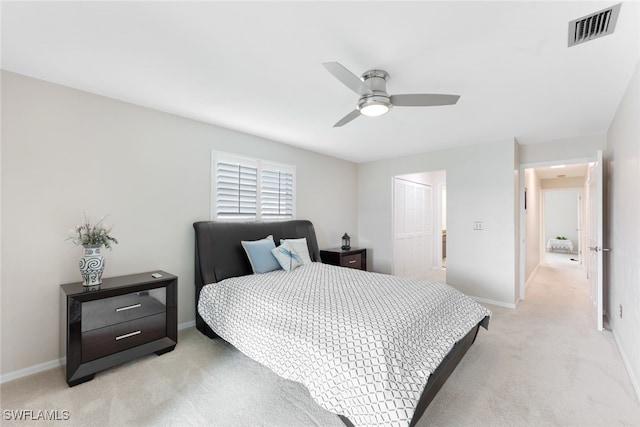 bedroom with light colored carpet, ceiling fan, and a closet