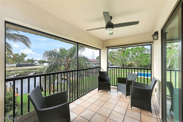 sunroom with a water view and ceiling fan