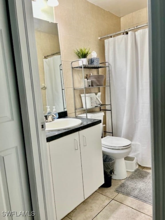 bathroom featuring tile walls, walk in shower, vanity, tile patterned flooring, and toilet