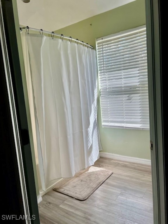 bathroom with hardwood / wood-style floors and curtained shower