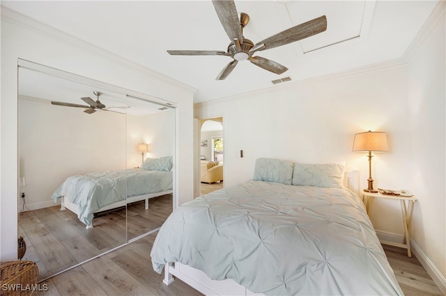 bedroom with ceiling fan, ornamental molding, and light hardwood / wood-style floors