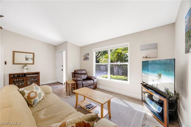 living room with vaulted ceiling and light hardwood / wood-style floors