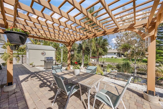 view of patio featuring area for grilling, a storage shed, and a pergola