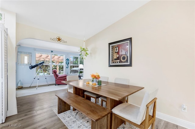 dining space featuring lofted ceiling and wood-type flooring