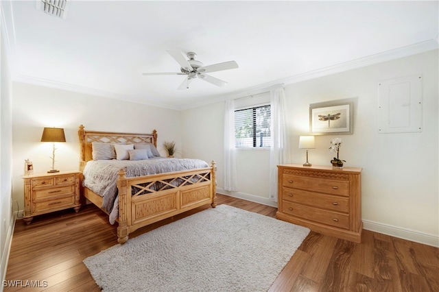 bedroom with crown molding, ceiling fan, electric panel, and hardwood / wood-style floors