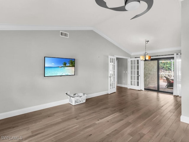 unfurnished living room with french doors, lofted ceiling, hardwood / wood-style floors, a notable chandelier, and ornamental molding