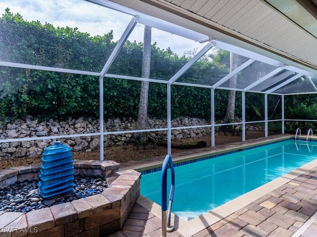 view of swimming pool with glass enclosure and a patio