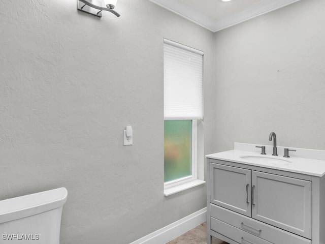 bathroom featuring vanity, a healthy amount of sunlight, toilet, and crown molding