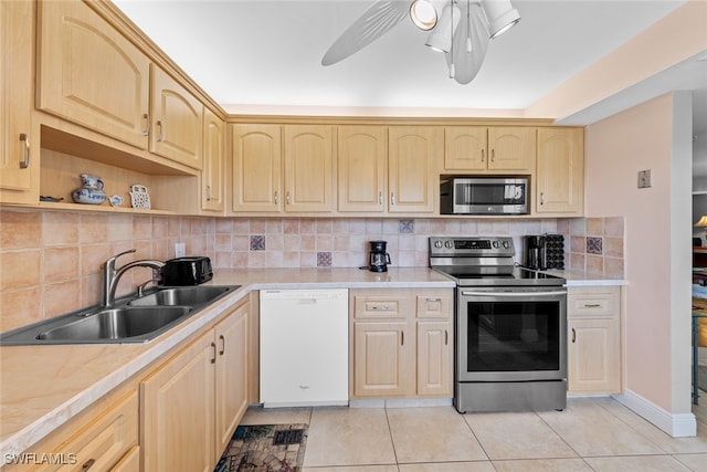 kitchen with decorative backsplash, light tile patterned floors, stainless steel appliances, and sink