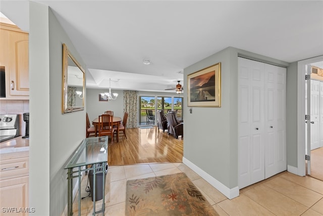 hall featuring a notable chandelier and light tile patterned floors