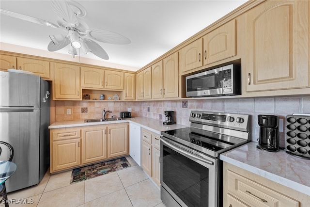 kitchen with sink, light brown cabinets, stainless steel appliances, tasteful backsplash, and light tile patterned floors