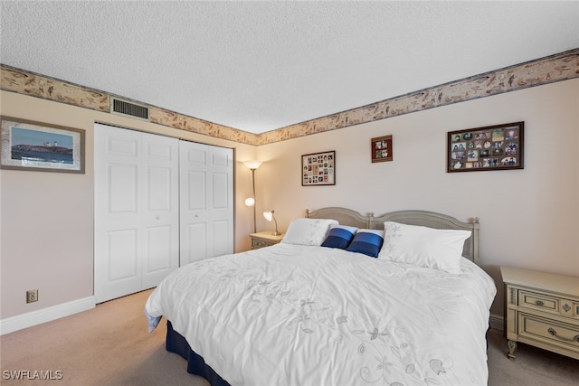 carpeted bedroom featuring a textured ceiling and a closet