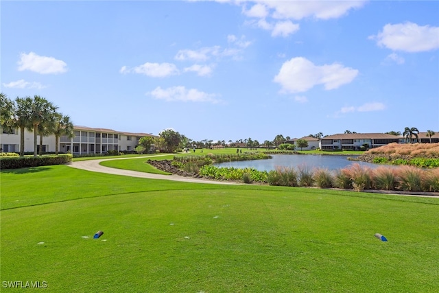 view of property's community with a lawn and a water view