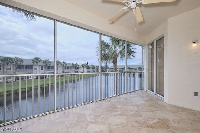 unfurnished sunroom with a water view, ceiling fan, and a healthy amount of sunlight