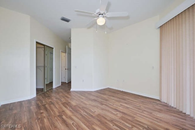 spare room with dark hardwood / wood-style flooring and ceiling fan