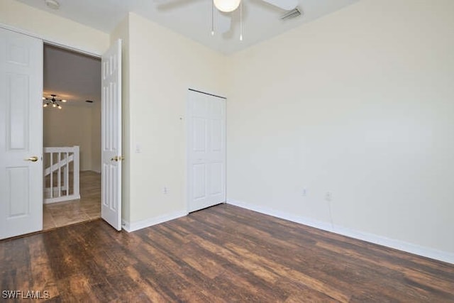 unfurnished bedroom with ceiling fan, visible vents, baseboards, and wood finished floors