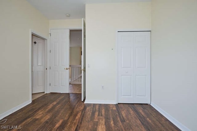 unfurnished bedroom featuring dark hardwood / wood-style floors and a closet