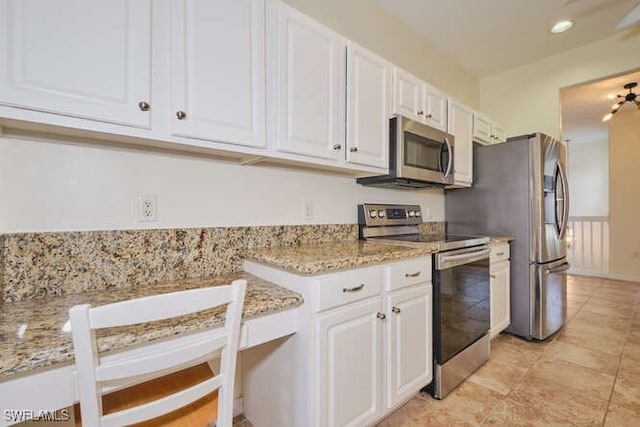 kitchen with white cabinetry, light stone counters, and appliances with stainless steel finishes