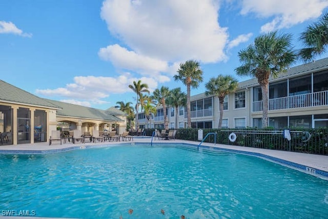 community pool with fence and a patio