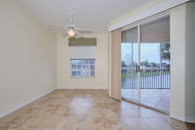 unfurnished room with a ceiling fan and baseboards