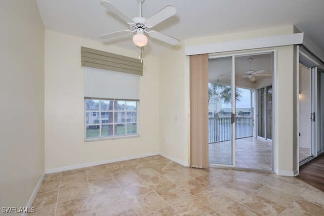 empty room featuring a ceiling fan and baseboards