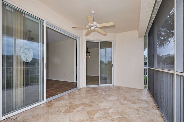 unfurnished sunroom with ceiling fan